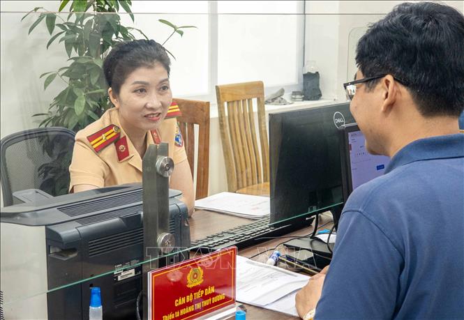 Cán bộ, chiến sĩ Công an phường Giảng Võ, Công an thành phố Hà Nội hướng dẫn người dân đến làm thủ tục đăng ký, cấp biển số phương tiện. Ảnh: Phạm Kiên - TTXVN