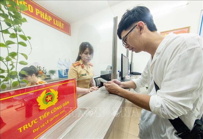 Cán bộ, chiến sĩ Công an phường Cửa Nam, thành phố Hà Nội tiếp nhận và hướng dẫn người dân đến làm thủ tục đăng ký xe mô tô. Ảnh: Phạm Kiên - TTXVN