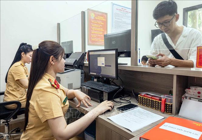 Người dân đến làm thủ tục đăng ký xe tại Công an phường Cửa Nam, thành phố Hà Nội. Ảnh: Phạm Kiên - TTXVN