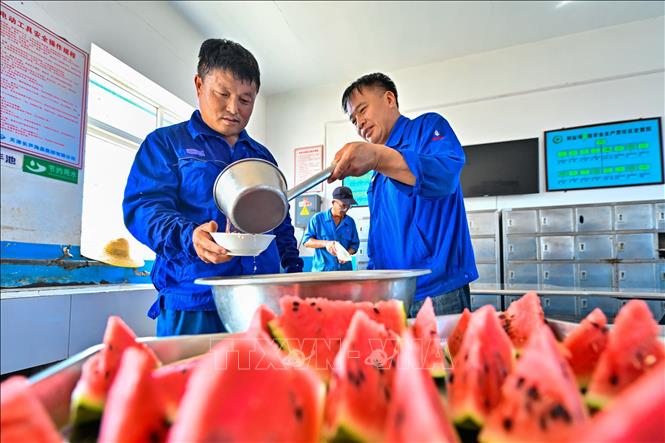 Công nhân thưởng thức súp đậu xanh và dưa hấu để giải nhiệt trong ngày nắng nóng tại Thiên Tân, Trung Quốc. Ảnh: THX/TTXVN