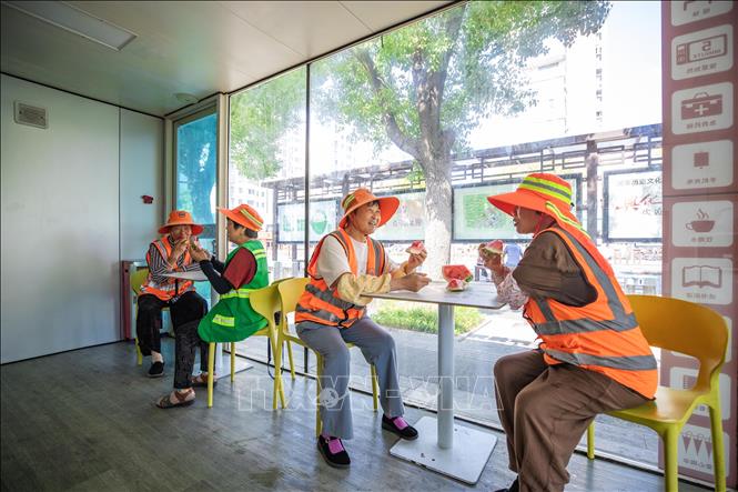 Công nhân ăn dưa hấu để giải nhiệt trong ngày nắng nóng tại tỉnh Giang Tô, Trung Quốc. Ảnh: THX/TTXVN