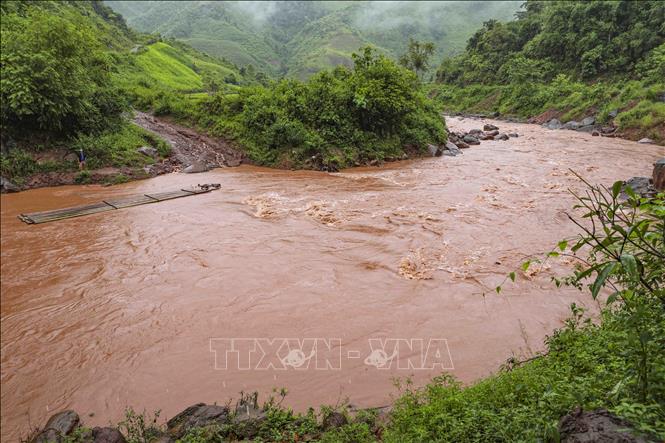 Không có cầu, bè tre là phương tiện duy nhất để người dân qua suối Nậm Chà. Ảnh: Xuân Tư - TTXVN