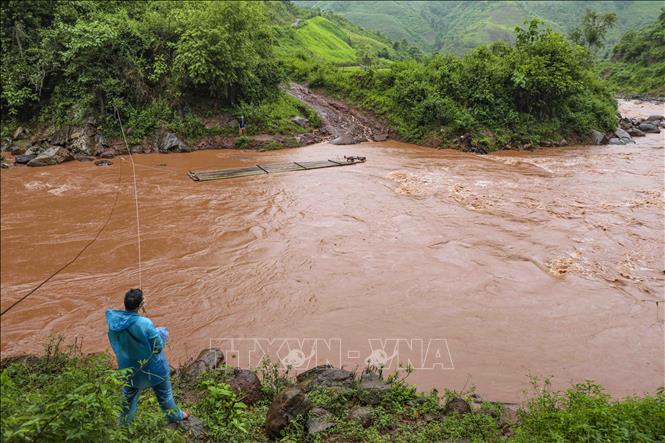 Không có cầu, bè tre là phương tiện duy nhất để người dân qua suối Nậm Chà. Ảnh: Xuân Tư - TTXVN