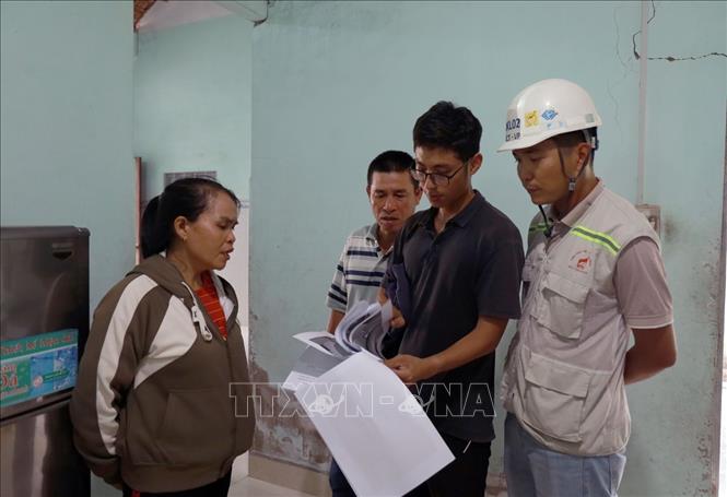 Người dân đối chiếu vết nứt được khảo sát trước thi công và hiện tại để có cơ sở giám định bồi thường thiệt hại. Ảnh: Xuân Triệu - TTXVN