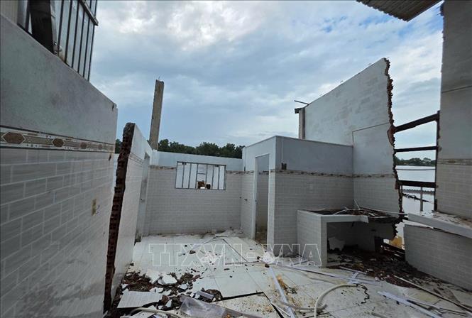 Nhiều tường nhà của người dân bị xé toạc, có thể đổ sập xuống sông bất kỳ lúc nào. Ảnh: TTXVN phát