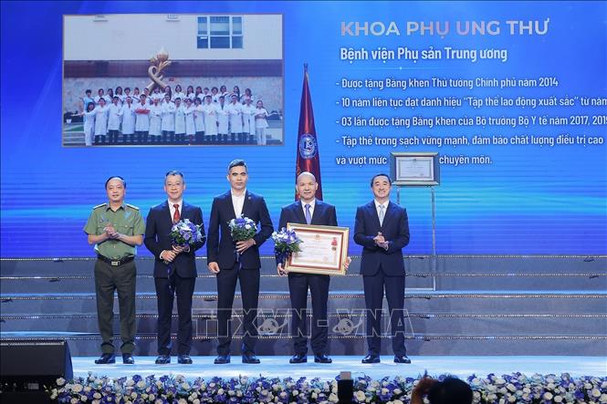 Thừa ủy quyền của Chủ tịch nước, Thứ trưởng Bộ Y tế Trần Văn Thuấn trao Huân chương Lao động hạng Ba cho tập thể Khoa Phụ ung thư, Bệnh viện Phụ sản Trung ương. Ảnh: Minh Quyết – TTXVN