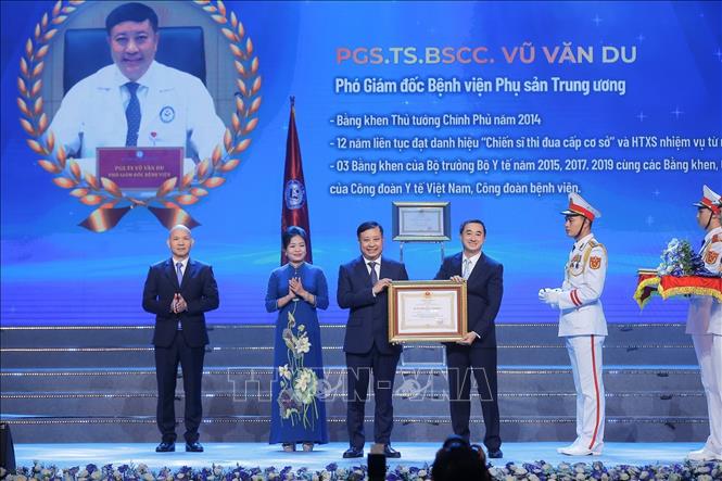 Thừa ủy quyền của Chủ tịch nước, Thứ trưởng Bộ Y tế Trần Văn Thuấn trao Huân chương Lao động hạng Ba cho PGS.TS.BSCC Vũ Văn Du, Phó Giám đốc Bệnh viện Phụ sản Trung ương. Ảnh: Minh Quyết – TTXVN