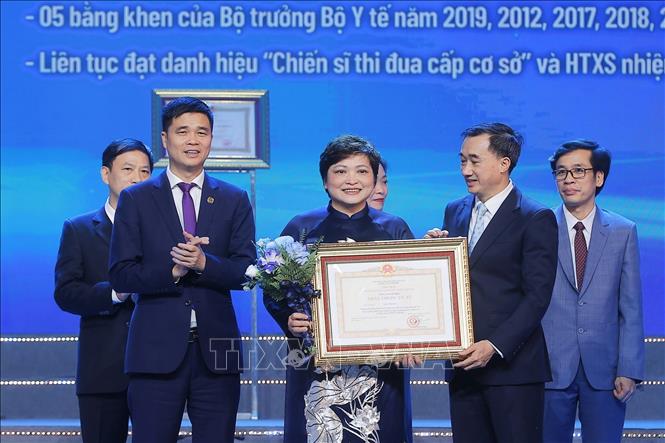Thừa ủy quyền của Chủ tịch nước, Thứ trưởng Bộ Y tế Trần Văn Thuấn trao danh hiệu Thầy thuộc Ưu tú cho TS.BS Đào Thị Thoa, Trưởng Khoa Khám bệnh, Bệnh viện Phụ sản Trung ương. Ảnh: Minh Quyết – TTXVN