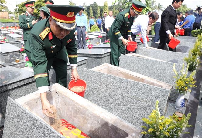 Đại tá Thái Thành Đức, Phó Chủ nhiệm Chính trị Quân khu 7 tham gia an táng hài cốt liệt sĩ. Ảnh: Đức Hạnh - TTXVN 
