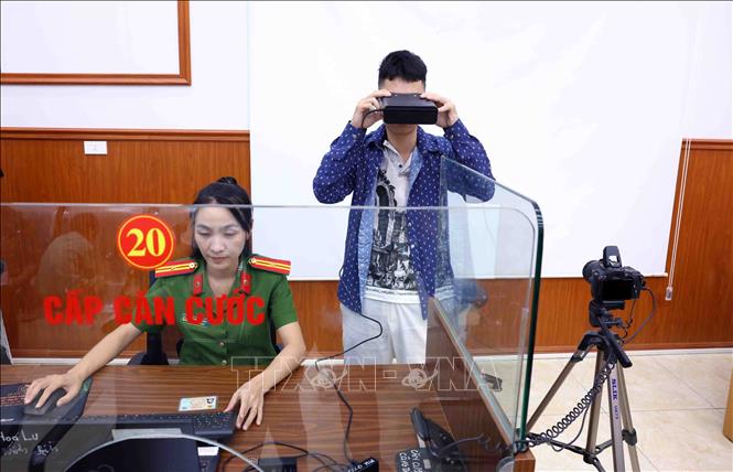 Người dân đến làm thẻ căn cước được cán bộ, chiến sĩ Công an phường Hoa Lư, tỉnh Ninh Bình thu thập sinh trắc học mống mắt. Ảnh: Phạm Kiên - TTXVN