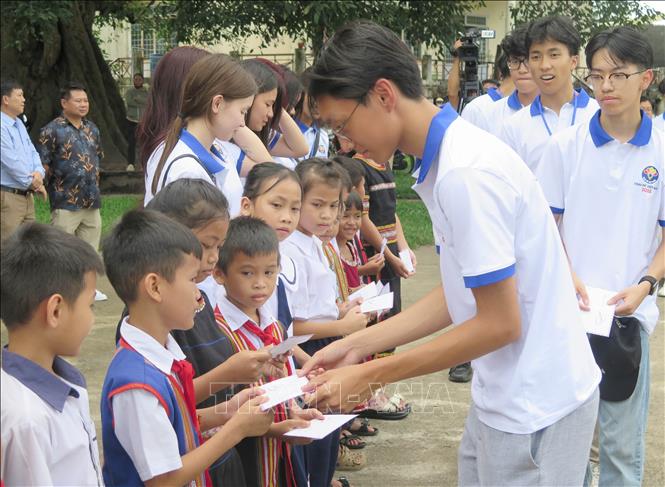 Các trại sinh Trại hè Việt Nam 2025 tặng quà cho học sinh có hoàn cảnh khó khăn có mặt tại Nhà rông Kon Klor. Ảnh: Dư Toán – TTXVN