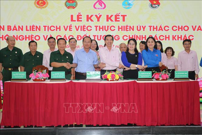 Đại diện Chi nhánh Ngân hàng Chính sách xã hội thành phố Cần Thơ ký kết văn bản phối hợp với đại diện 4 hội đoàn thể. Ảnh: Thu Hiền - TTXVN