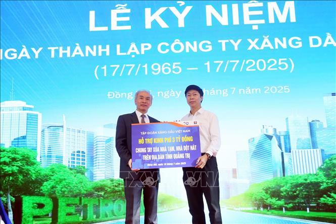Đại diện Tập đoàn Xăng dầu Việt Nam - Petrolimex (bên trái) trao biển tượng trưng tặng 3 tỷ đồng xóa nhà tạm, nha dột nát cho Ủy ban Mặt trận Tổ quốc tỉnh Quảng Trị. Ảnh: Tá Chuyên - TTXVN