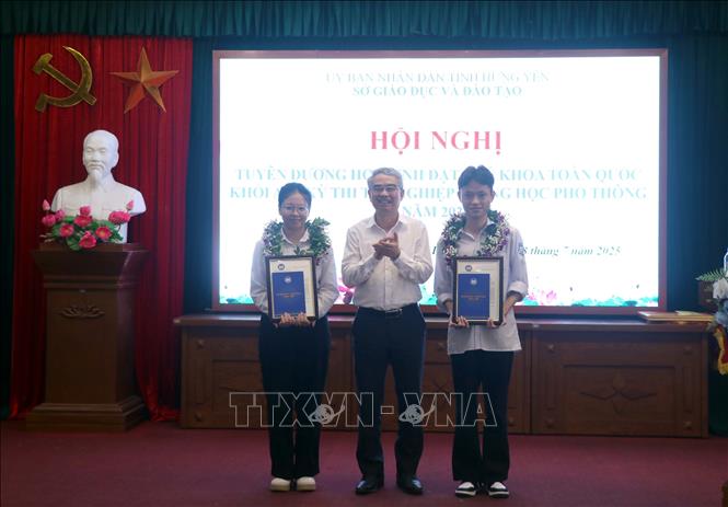 Giám đốc Sở Giáo dục và Đào tạo tỉnh Hưng Yên Phạm Đồng Thụy trao thư khen của Sở Giáo dục và Đào tạo cho hai học sinh đạt thủ khoa toàn quốc khối A00. Ảnh: Đinh Văn Nhiều-TTXVN