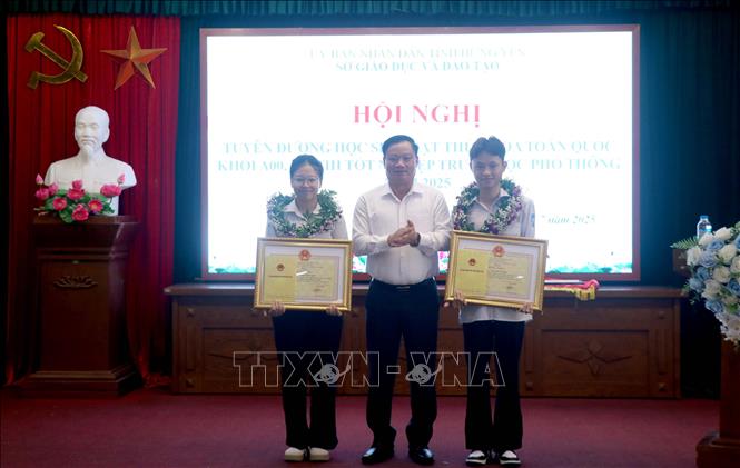 Chủ tịch UBND tỉnh Hưng Yên Nguyễn Khắc Thận trao Bằng khen cho hai học sinh đạt thủ khoa toàn quốc khối A00. Ảnh: Đinh Văn Nhiều-TTXVN