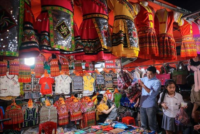 Visitors browse for local brocade products while enjoying shopping and entertainment at the Sa Pa night market. Photo: Hoàng Hiếu – VNA
