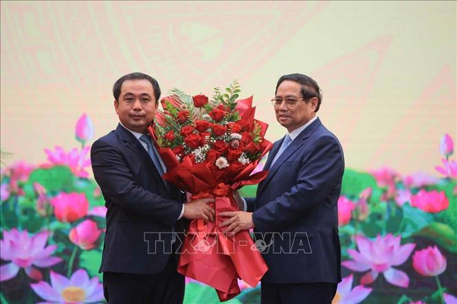 Thủ tướng Phạm Minh Chính tặng hoa chúc mừng quyền Bộ trưởng Bộ Nông nghiệp và Môi trường Trần Đức Thắng. Ảnh: Hoàng Hiếu - TTXVN