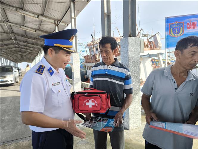 Trao túi thuốc y tế cho ngư dân trước khi ra khơi. Ảnh: Huỳnh Phúc Hậu - TTXVN