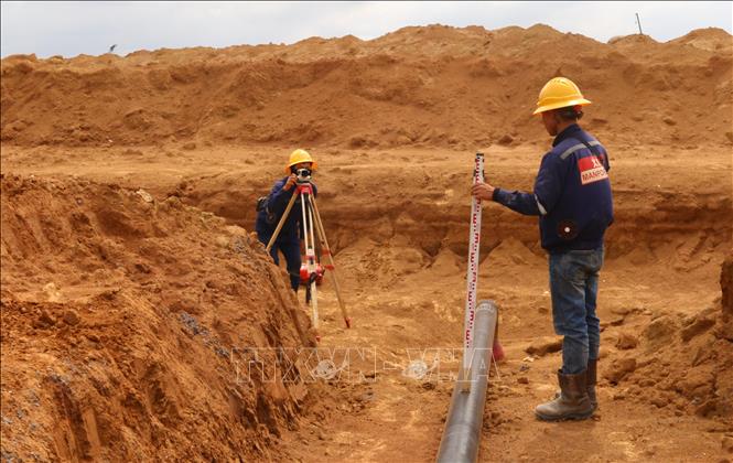 Người lao động căn chỉnh vị trí đặt ống ngầm cung cấp nhiên liệu phục vụ sân bay Long Thành. Ảnh: Công Phong - TTXVN