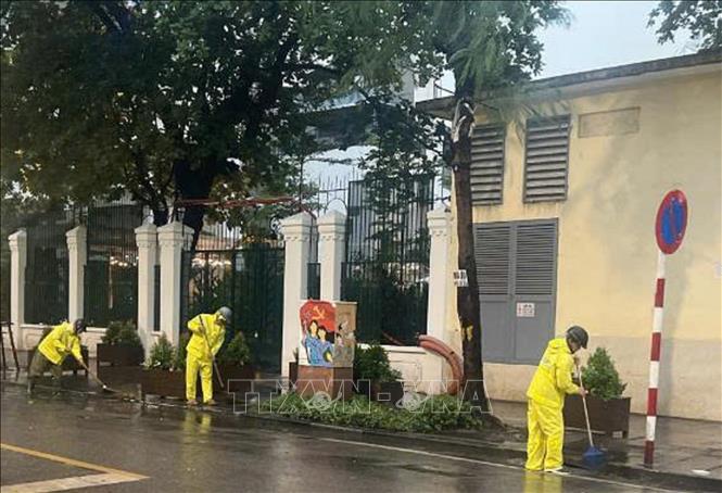 Công nhân Công ty TNHH MTV Thoát nước Hà Nội khẩn trương ứng trực kịp thời tiêu thoát nước đoạn ngã 4 Phan Bội Châu - Lý Thường Kiệt. Ảnh: Nguyễn Thắng - TTXVN