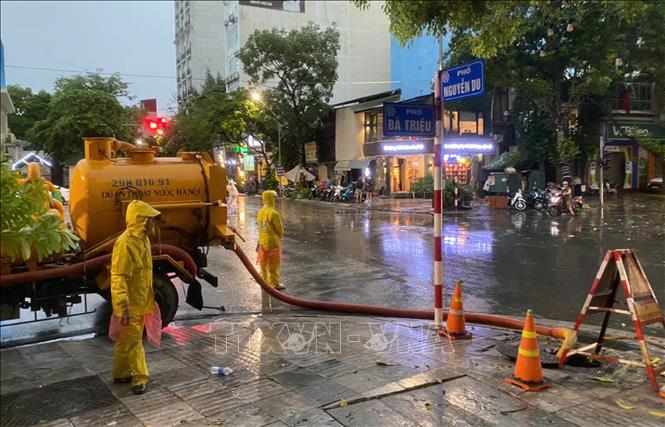 Công nhân Công ty TNHH MTV Thoát nước Hà Nội khẩn trương ứng trực kịp thời tiêu thoát nước đoạn ngã 4 Nguyễn Du - Bà Triệu. Ảnh: Nguyễn Thắng - TTXVN