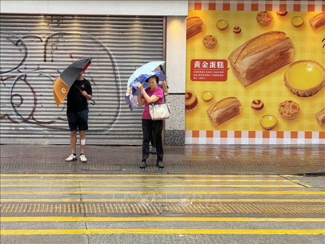 Người dân chờ qua đường vào sáng 20/7. Ảnh: Mạc Luyện PV TTXVN tại Hong Kong