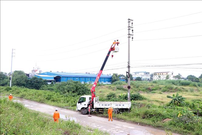 Đội quản lý điện khu vực Hải Dương (Công ty Điện lực Hải Phòng) lắp đặt thiết bị chống sét cho hệ thống cột và dây điện. Ảnh: Mạnh Tú - TTXVN
