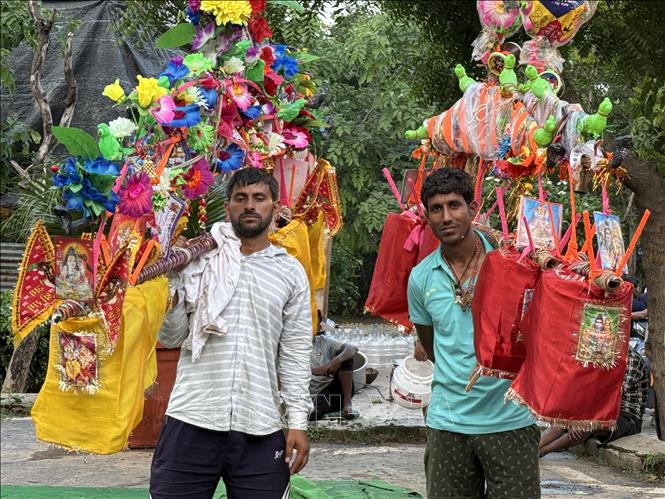 Các tín đồ Hindu thay nhau gánh Kanwar để bạn đồng hành nghỉ ngơi tại một trạm dừng chân ở thủ đô New Delhi. Ảnh: Ngọc Thúy - PV TTXVN tại New Delhi.