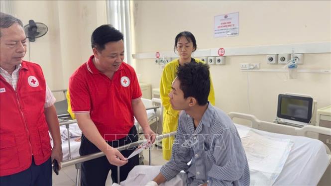 Ông Trần Sĩ Pha, Trưởng Ban Công tác xã hội - Quản lý thảm hoạ Trung ương Hội Chữ thập đỏ Việt Nam thăm hỏi các nạn nhân đang điều trị tại bệnh viện. Ảnh: TTXVN phát