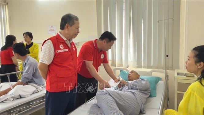 Ông Trần Sĩ Pha, Trưởng Ban Công tác xã hội - Quản lý thảm hoạ TƯ Hội Chữ thập đỏ Việt Nam thăm hỏi các nạn nhân đang điều trị tại bệnh viện. Ảnh: TTXVN phát