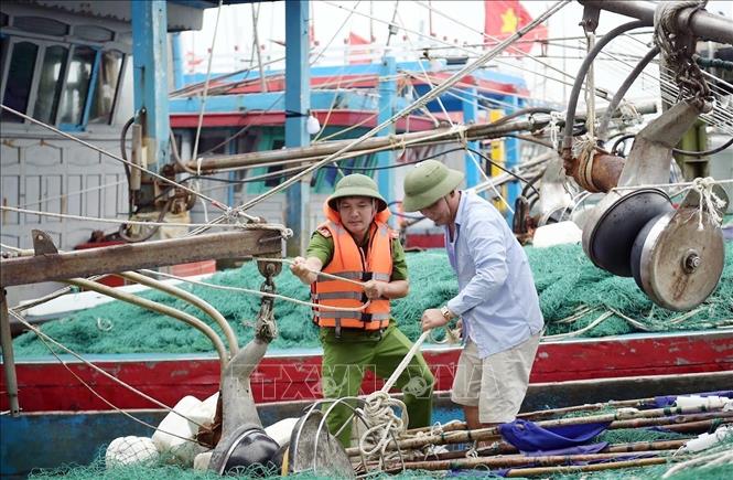 Lực lượng chức năng hướng dẫn, giúp ngư dân xã Hải Thịnh (Ninh Bình) phòng chống bão. Ảnh: Thái Thuần – TTXVN