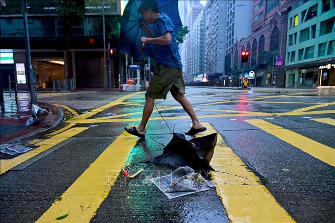 Người dân di chuyển trên đường phố trong gió lớn do ảnh hưởng của bão Wipha tại Hong Kong, Trung Quốc. Ảnh: THX/TTXVN