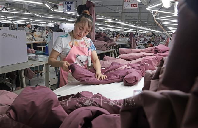 Kiểm tra, hoàn thiện sản phẩm áo khoác xuất khẩu tại Công ty. Ảnh: Trần Việt - TTXVN