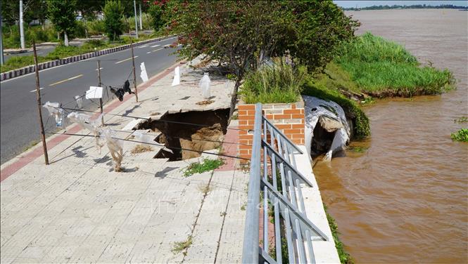 Sạt lở ăn sâu vào chân Kè Thường Thới Tiền gây sụp lún phần vỉa hè, tạo thành một hố sâu. Ảnh: Nhựt An - TTXVN