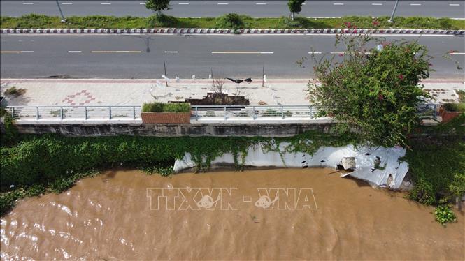 Sạt lở ăn sâu vào chân Kè Thường Thới Tiền (xã Thường Phước, tỉnh Đồng Tháp), gây sụp lún phần vỉa hè, tạo thành một hố sâu. Ảnh: Nhựt An - TTXVN