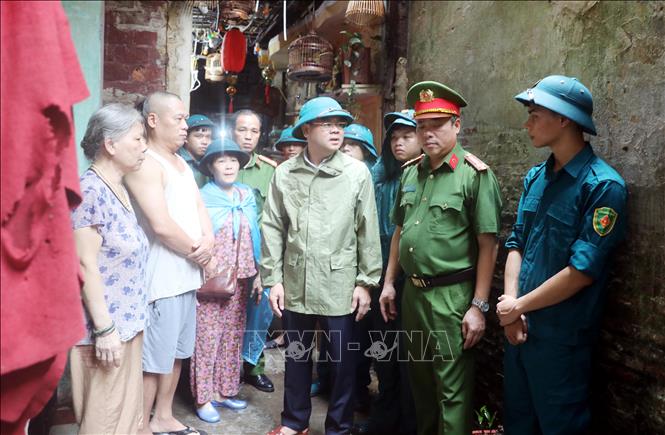 Các lực lượng chức năng phường phường Nam Định, tỉnh Ninh Bình, vận động người dân di chuyển đến nơi ở an toàn. Ảnh: Thái Thuần – TTXVN