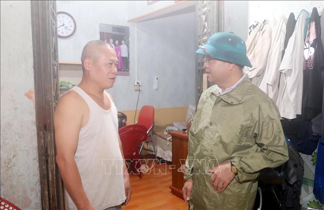 Chủ tịch UBND phường Nam Định Phạm Hồng Thái vận động người dân di chuyển đến nơi ở an toàn. Ảnh: Thái Thuần – TTXVN