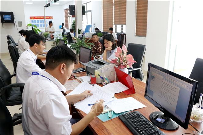 Lãnh đạo, cán bộ, công chức, viên chức xã Trường Tân làm việc cả ngày thứ 7, chủ nhật để giải quyết thủ tục hành chính cho người dân. Ảnh: Mạnh Tú - TTXVN