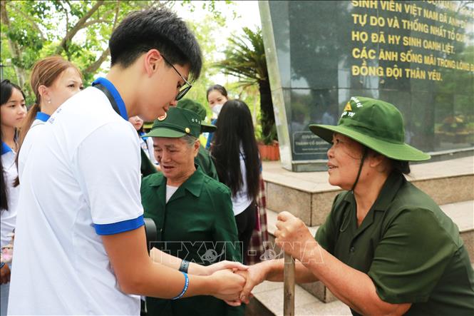 Đoàn thanh niên, sinh viên kiều bào trò chuyện với các các cựu chiến bình và thanh niên xung phong. Ảnh: Tường Vi - TTXVN. 