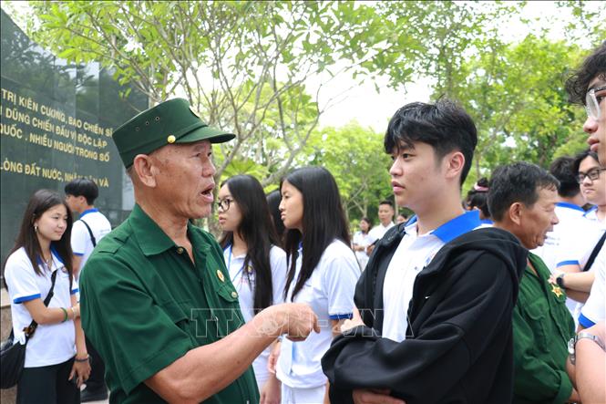 Đoàn thanh niên, sinh viên kiều bào trò chuyện với các cựu chiến bình và thanh niên xung phong. Ảnh: Tường Vi - TTXVN. 