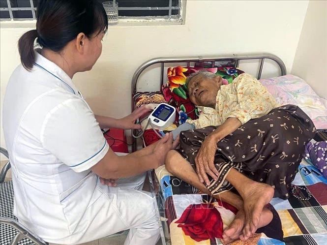 Chăm sóc y tế cho người già thuộc diện di dời tránh bão. Ảnh: TTXVN phát