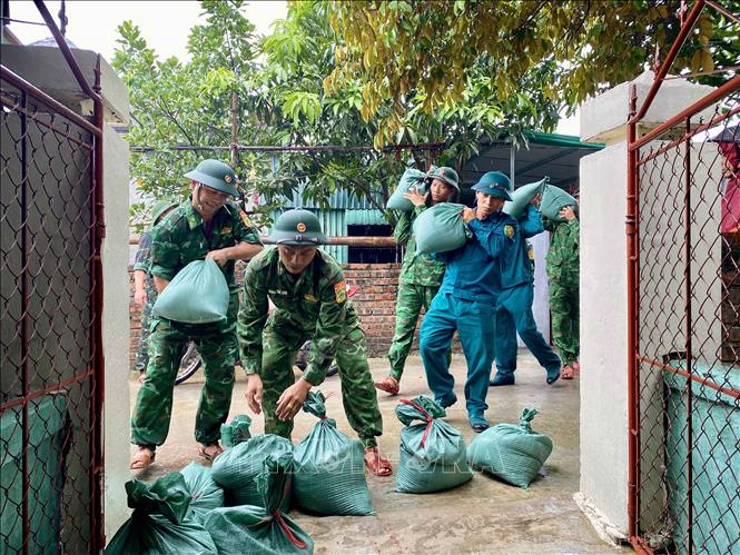 Bộ đội vận chuyển bao cát để gia cố mái nhà cho người dân xã Đan Hải (Hà Tĩnh). Ảnh: Hữu Quyết - TTXVN