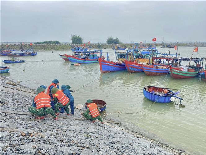 Lực lượng quân đội hỗ trợ người dân xã Đan Hải chằng néo lại tàu thuyền. Ảnh: Hữu Quyết - TTXVN
