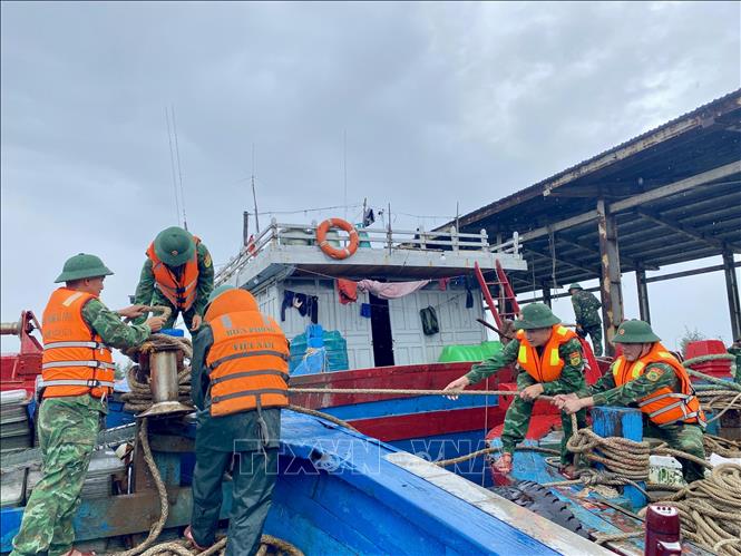 Bộ đội biên phòng hỗ trợ ngư dân gia cố, chằng néo tàu thuyền. Ảnh: Hữu Quyết - TTXVN