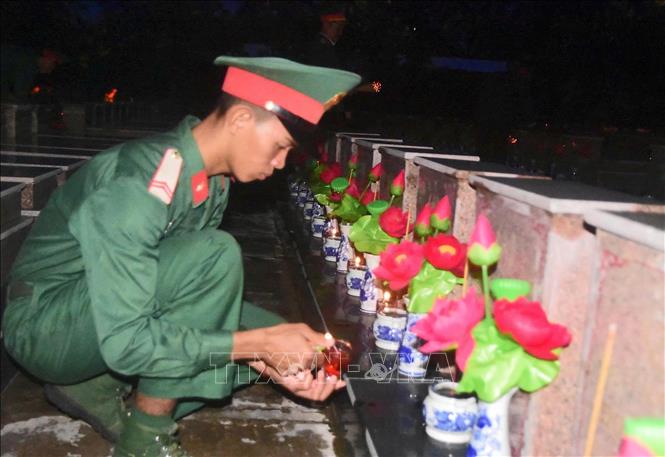 Chiến sĩ tỉnh An Giang thắp nến tại phần mộ các Anh hùng liệt sĩ. Ảnh: TTXVN phát