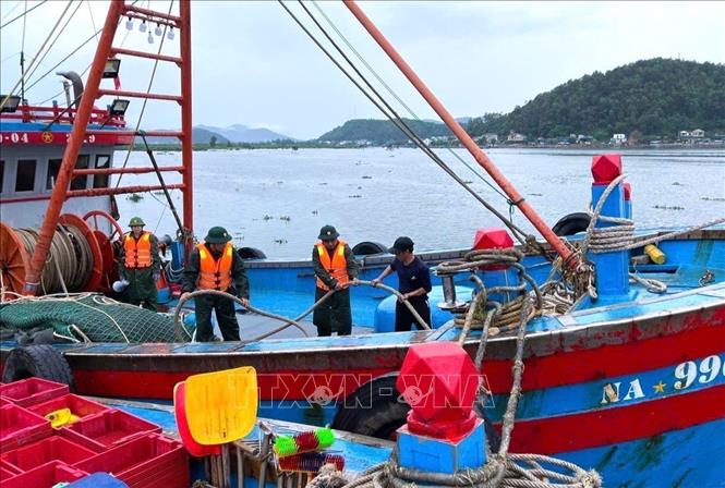 Border guards in central province of Nghe An assist local fishermen prepare for the storm. VNA/Photo by courtesy