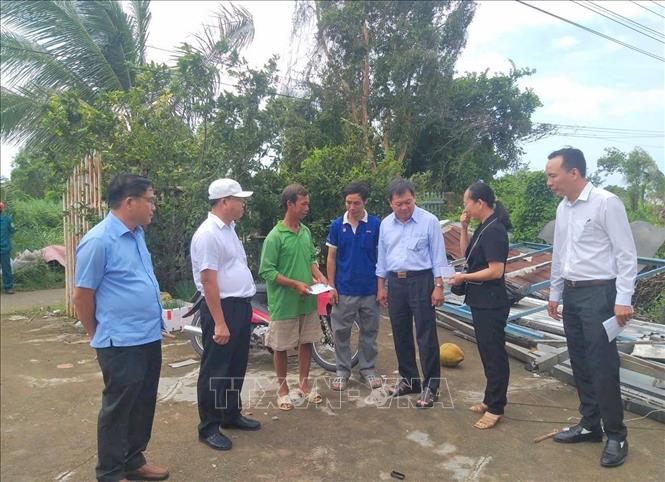 Lãnh đạo Ủy ban MTTQ Việt Nam tỉnh An Giang và phường Vĩnh Thông thăm hỏi, động viên và trao tiền hỗ trợ bước đầu cho các hộ dân bị ảnh hưởng của bão số 3. Ảnh: Công Mạo-TTXVN