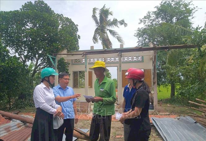 Lãnh đạo Ủy ban MTTQ Việt Nam tỉnh An Giang và phường Vĩnh Thông thăm hỏi, động viên và trao tiền hỗ trợ bước đầu cho các hộ dân bị ảnh hưởng của bão. Ảnh: Công Mạo-TTXVN