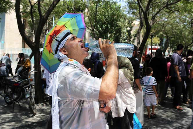 Người dân uống nước giải nhiệt dưới thời tiết nắng nóng tại Tehran, Iran ngày 22/7/2025. Ảnh: THX/TTXVN