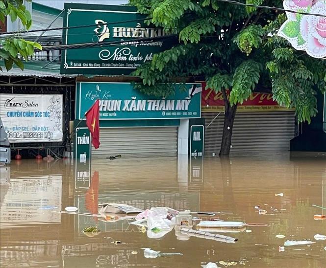 Của hàng trên Quốc lộ 7 đoạn qua xã Tương Dương bị ngập lụt.  Ảnh: TTXVN phát